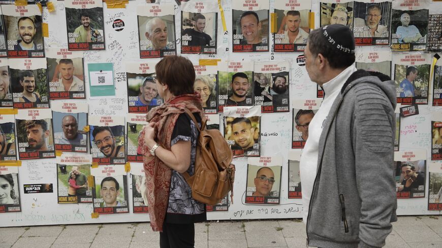People view posters of missing Israelis on a wall at Hostages Square, Tel Aviv, Feb.12, 2024.