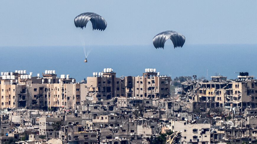 This picture taken from Israel's southern border with the Gaza Strip shows parachutes of humanitarian aid dropping over the besieged Palestinian territory on March 26, 2024, amid the ongoing conflict between Israel and the militant group Hamas. 