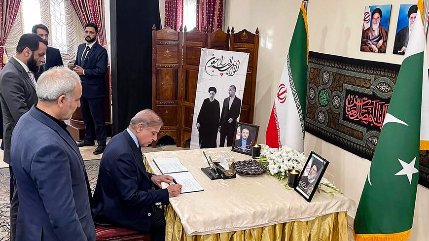 Pakistan's prime minister, Shehbaz Sharif, writes a condolence note in a book for Iran's late president, Ebrahim Raisi, and Foreign Minister Hossein Amir-Abdollahian, who died in a helicopter crash at the Iran embassy in Islamabad on May 20, 2024. 