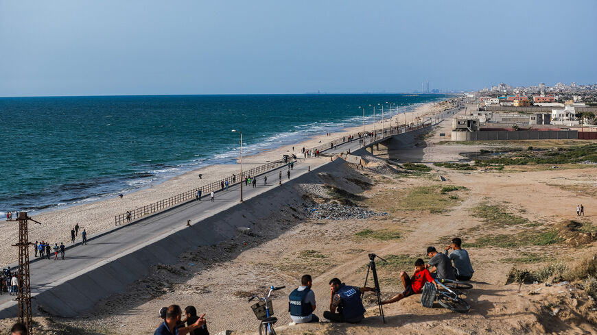 Palestinians watch US military ships in the Gaza floating pier on the Mediterranean Sea offshore installed by the US military to deliver aid to Gazans, Gaza Strip, May 17, 2024.