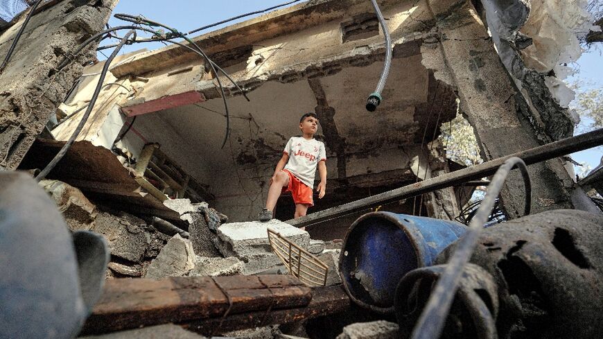 A Palestinian boy stands in a destroyed house in Gaza's Nuseirat area following Israeli bombardment overnight, on May 23, 2024