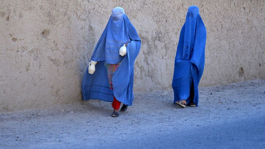 Afghan women walk along a road in Arghandab district of Kandahar province on May 27, 2024