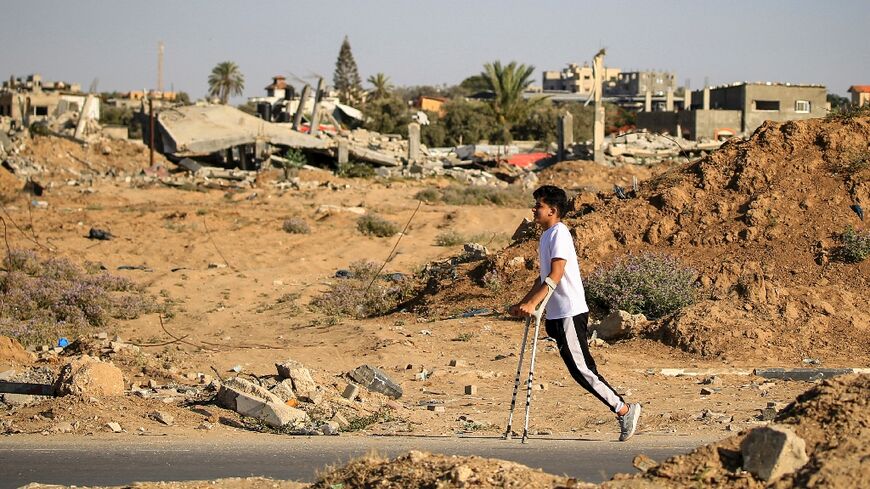 An amputee makes his way past buildings destroyed during Israeli bombardment, at al-Bureij refugee camp, central Gaza 