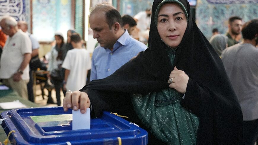 An Iranian woman casts her vote at a polling station in Tehran during the Islamic republic's presidential election
