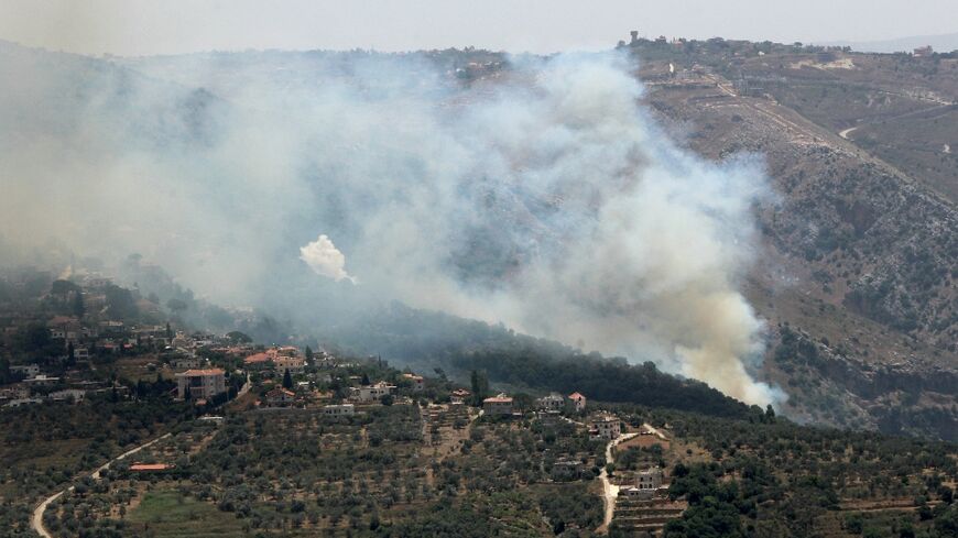 Smoke billows from fires ignited by Israeli shelling on the forested areas of the southern Lebanese village of Deir Mimas