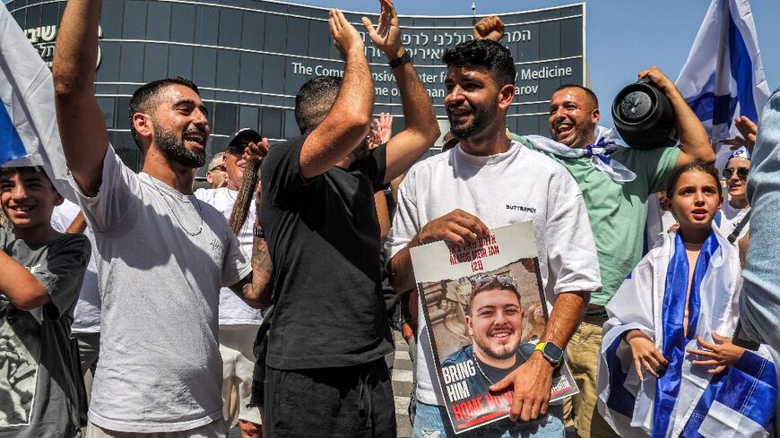 A man holds a picture of Almog Meir Jan, one of four Israeli hostages rescued from captivity in the Gaza Strip on Saturday