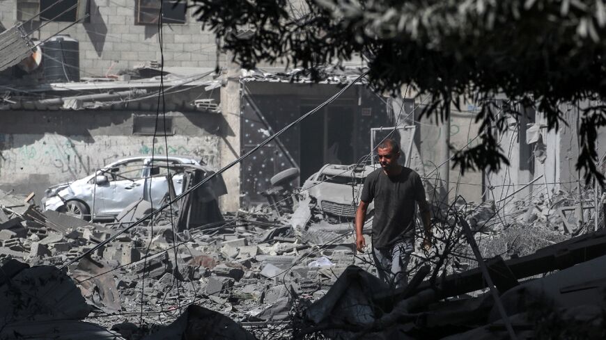 A Palestinian looks at the debris from fighting following the hostage rescue operation by Israeli special forces in Nuseirat camp, central Gaza, on June 8, 2024