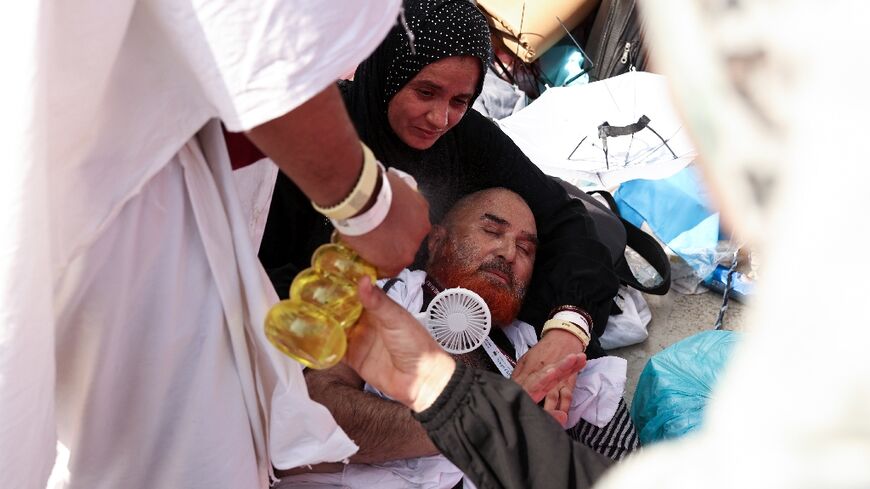 A man effected by the scorching heat is helped by other Muslim in Mina, near Saudi Arabia's holy city of Mecca