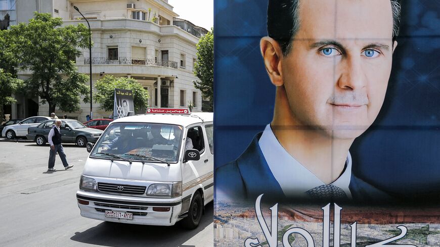 A large sign put up by private citizens bearing the portrait of Syria's President Bashar al-Assad, with text in Arabic below reading "total allegiance", is displayed along Abo Romaneh street in the capital Damascus on May 10, 2021 ahead of the country's presidential elections. - A Syrian former minister and a member of the Damascus-tolerated opposition will face Assad in the May 26 presidential election, according to the constitutional court in Syria. The election will be the second since the start of a dec