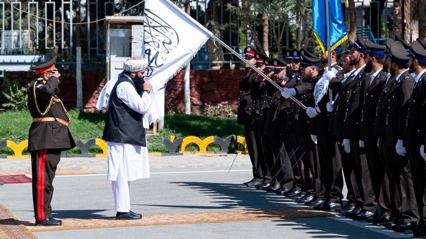 Taliban Interior Minister Sirajuddin Haqqani (C) kisses the Taliban flag as he reviews the newly recruited Afghan security personnel during their graduation ceremony at the police academy in Kabul on October 5, 2023. (Photo by Wakil KOHSAR / AFP) (Photo by WAKIL KOHSAR/AFP via Getty Images)