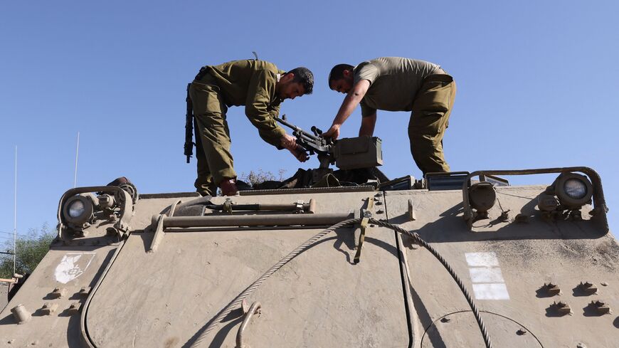 Israeli soldiers mount a weapon atop a tank as troops gather at a position in the upper Galilee region of northern Israel near the border with Lebanon on November 7, 2023, amid increasing cross-border tensions between Hezbollah and Israel as fighting continues in the south with Hamas militants in the Gaza Strip. (Photo by Jalaa MAREY / AFP) (Photo by JALAA MAREY/AFP via Getty Images)
