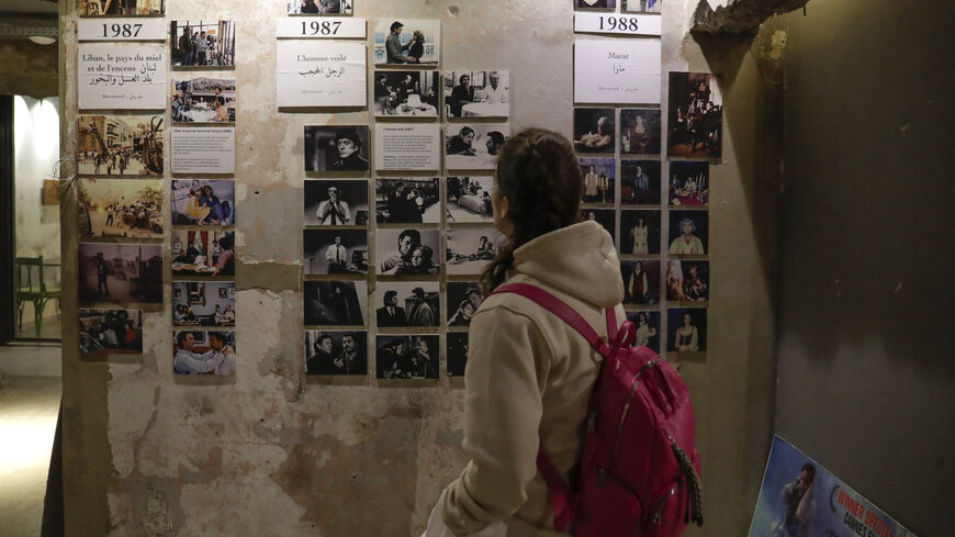 A visitor looks at portraits of late Franco-Lebanese film director Maroun Baghdadi and pictures from his movies at the venue of an exhibition dedicated to his memory in Beirut on December 12, 2023, as Lebanon commemorates the 30th annivesary of his death in an accident at the age of 43. (Photo by ANWAR AMRO / AFP) (Photo by ANWAR AMRO/AFP via Getty Images)