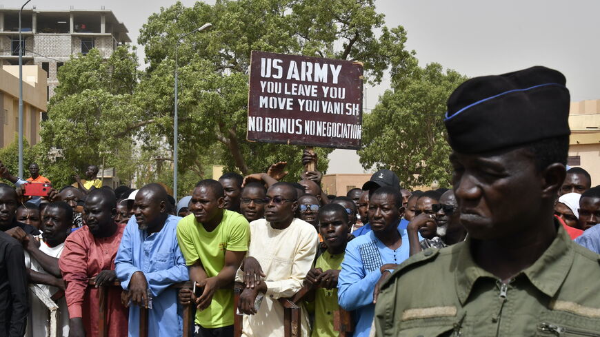 Protesters gather as a man holds up a sign demanding that soldiers from the United States Army leave Niger without negotiation during a demonstration in Niamey, on April 13, 2024. 
