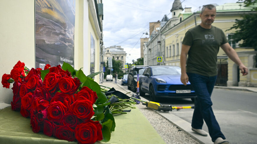 A man walks past the flowers laying in front of the representative office of Dagestan in Moscow on June 24, 2024, following terrorist attacks in Dagestan.  