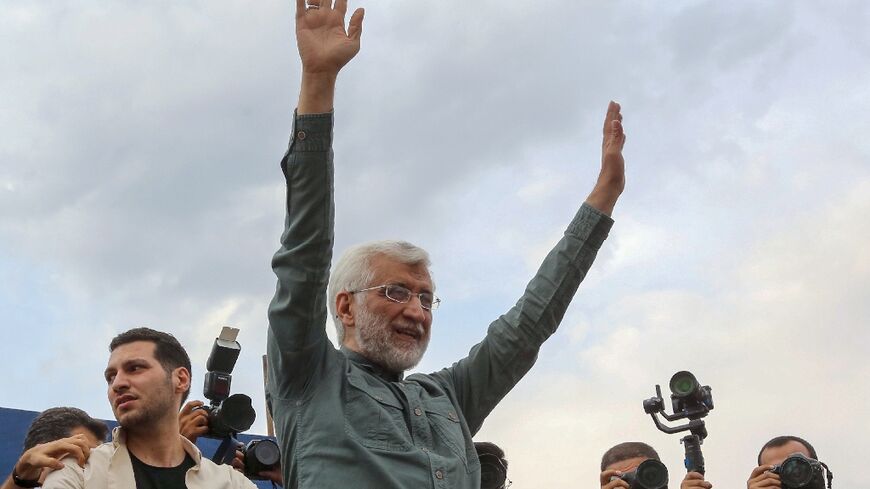 Ultraconservative former Iranian nuclear negotiator Saeed Jalili waves to supporters during a campaign event in Tehran