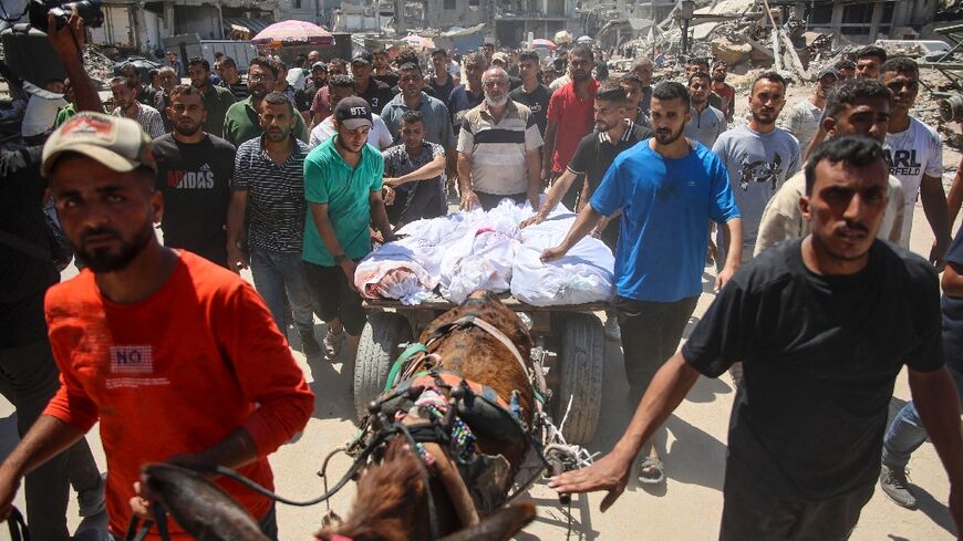 Palestinians transport the bodies of loved ones killed during Israeli bombardment of Gaza City's Al-Tuffah neighbourhood
