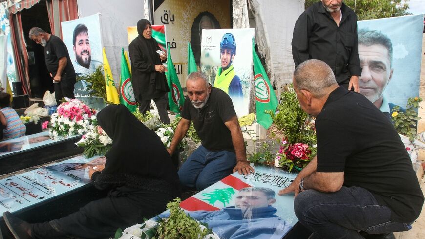Relatives visit the graves of killed Hezbollah fighters during Eid al-Adha in the southern Lebanese town of Naqura