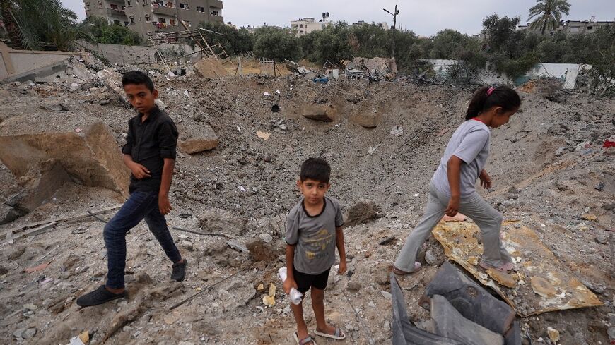 Palestinian children near the crater left by an Israeli strike in Nuseirat in the central Gaza Strip on June 3, 2024