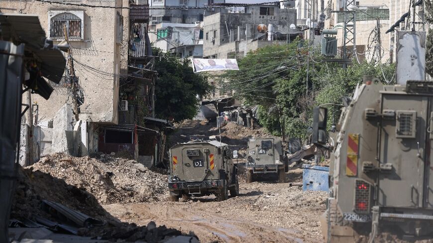 A column of Israeli military vehicles enters Tulkarem refugee camp in the occupied West Bank down roads stripped of asphalt as a precaution against bombs or mines