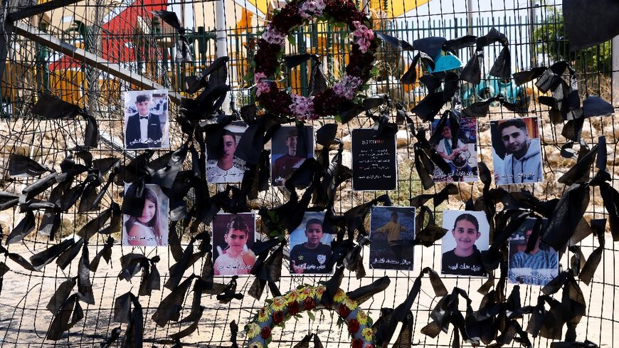 Portraits of the children and teens hang on the football stadium fence where a rocket landed and killed them, in the Druze Arab village of Majdal Shams, in the Israel annexed Golan Heights