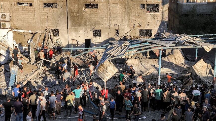 People search the rubble at a UN-run school in Gaza after an Israeli strike which Hamas said killed 16 people