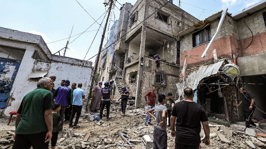 People inspect a building that was heavily damaged during an Israeli army raid on the Nur Shams camp for Palestinian refugees, east of Tulkarm in the occupied West Bank