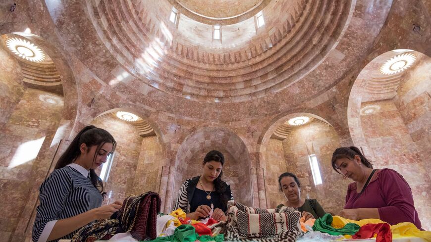 Women worshippers stand at the altar, they pray and tie knots in pieces of cloth that represent their wishes, during their visit to the new Yazidi Temple in the village of Aknalich, 35 kilometres from the Armenian capital Yerevan, on October 11, 2019.