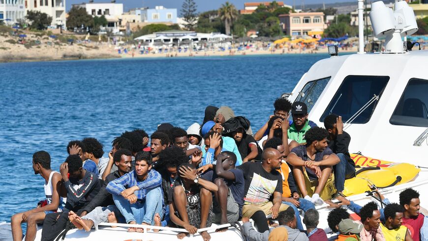 Migrants from Tunisia and Lybia arrive onboard of an Italian Guardia Costiera (Coast Guard) boat in the Italian Pelagie Island of Lampedusa on Aug. 1, 2020.