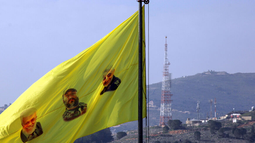 A flag bearing portraits of (L-R) slain Iraqi commander Abu Mahdi al-Muhandis, Hezbollah military leader Imad Moghniyeh, and Iranian Revolutionary Guards commander Qasem Soleimani, flutters after a raising ceremony by Lebanon's Hezbollah supporters and members on a hill facing the Israeli northern town of Metula by the border with Lebanon, on January 3, 2021, to mark the first anniversary of the killing of Soleimani and al-Muhandis in a US drone strike. (Photo by Ali DIA / AFP) (Photo by ALI DIA/AFP via Get