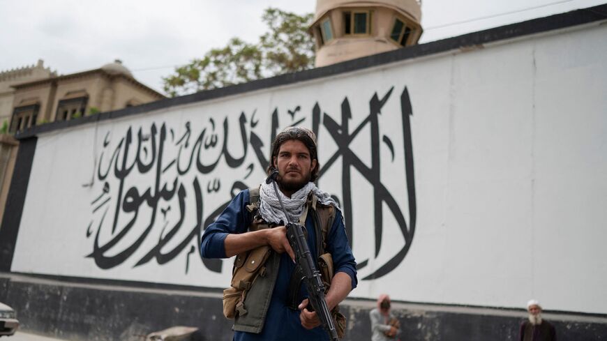 A Taliban fighter stands guard outside the US embassy as people demonstrate against videos of allegedly showing Afghan refugees being beaten by Iranians went viral, near the Ahmad Shah Massoud square in Kabul on April 12, 2022.