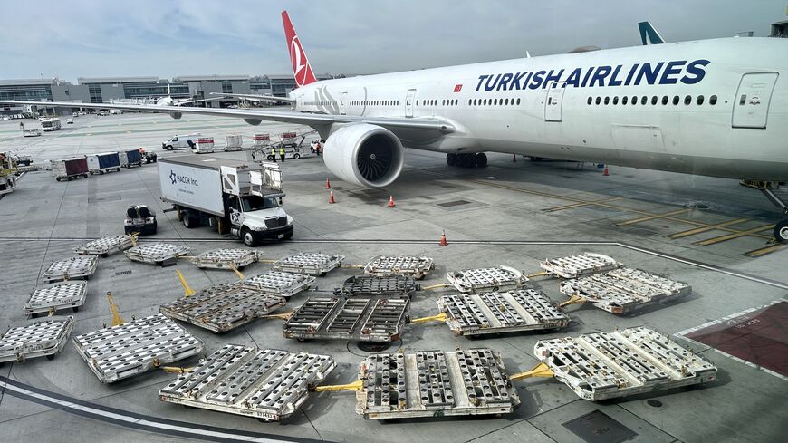 Empty baggage trucks are seen by a Turkish airlines Boeing 777, Los Angeles International Airport (LAX), Jan. 11, 2023.