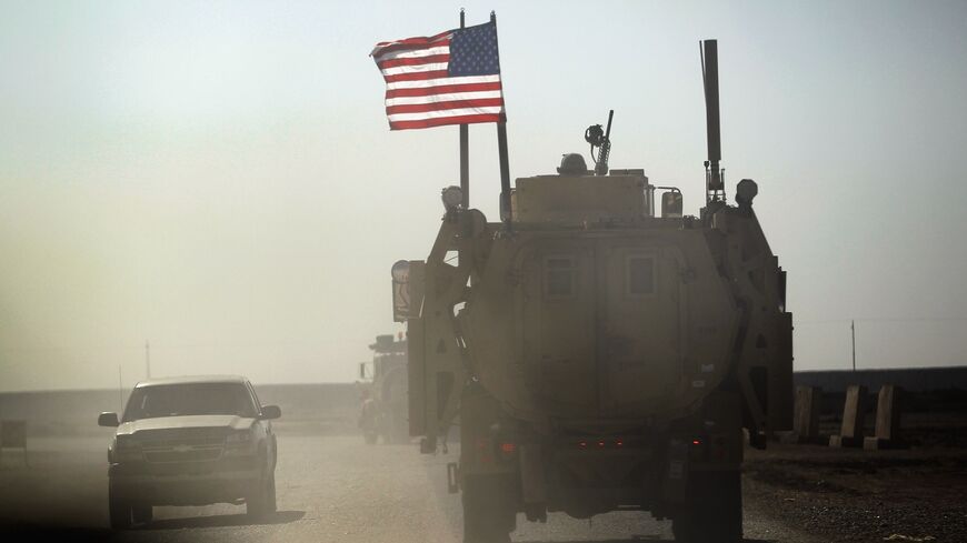 A US Army armored vehicle flies an American flag as it provides security escort for a convoy of vehicles pulling equipment that is heading to Kuwait from Camp Adder as the Army continues to send it's soldiers and equipment home and the base is prepared to be handed back to the Iraqi government later this month on December 2, 2011, at Camp Adder, near Nasiriyah, Iraq.