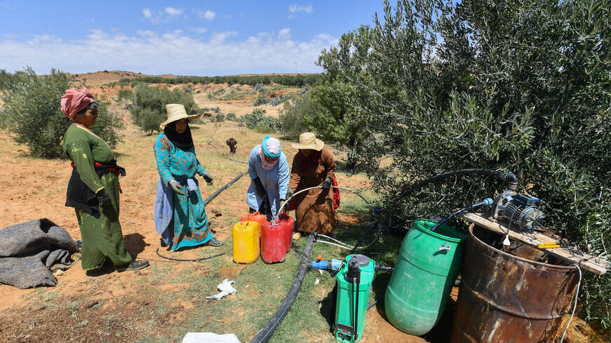Women queue to fill containers with water from a private irrigation well provided by a farmer in Sbikha town, which has been having drinking water problems for years, near Tunisia's central city of Kairouan on June 25, 2024. Like its neighbour Algeria and large areas of the Mediterranean region, Tunisia suffers from "alert drought conditions", according to the European Drought Observatory. (Photo by FETHI BELAID / AFP) (Photo by FETHI BELAID/AFP via Getty Images)