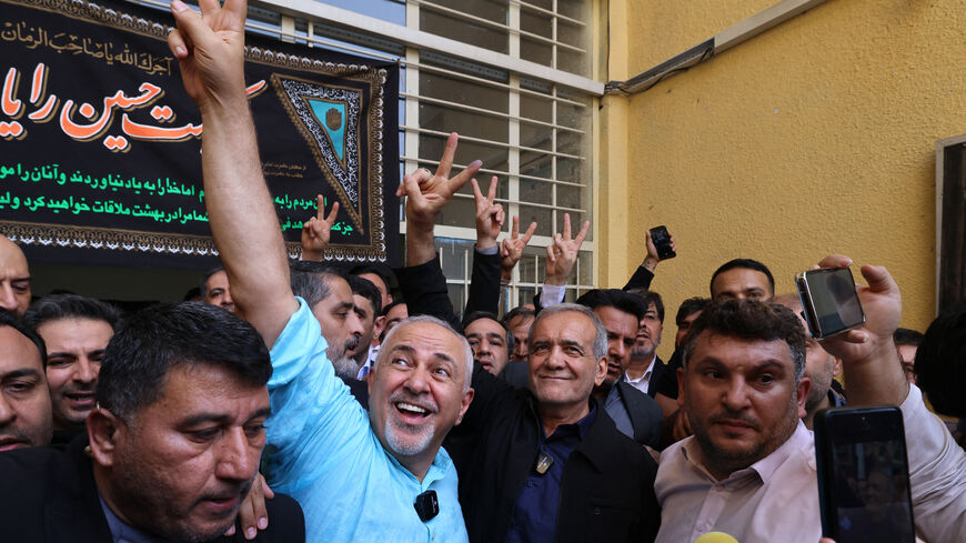 Iranian reformist candidate Masoud Pezeshkian (C-R) and Iran's former foreign minister Mohammad Javad Zarif (C-L) gesture after voting in Tehran on July 5, 2024. Polls opened on July 5 for Iran's runoff presidential election, the interior ministry said, pitting reformist candidate Masoud Pezeshkian against ultraconservative Saeed Jalili in the race to succeed Ebrahim Raisi, who died in a May helicopter crash. (Photo by ATTA KENARE / AFP) (Photo by ATTA KENARE/AFP via Getty Images)