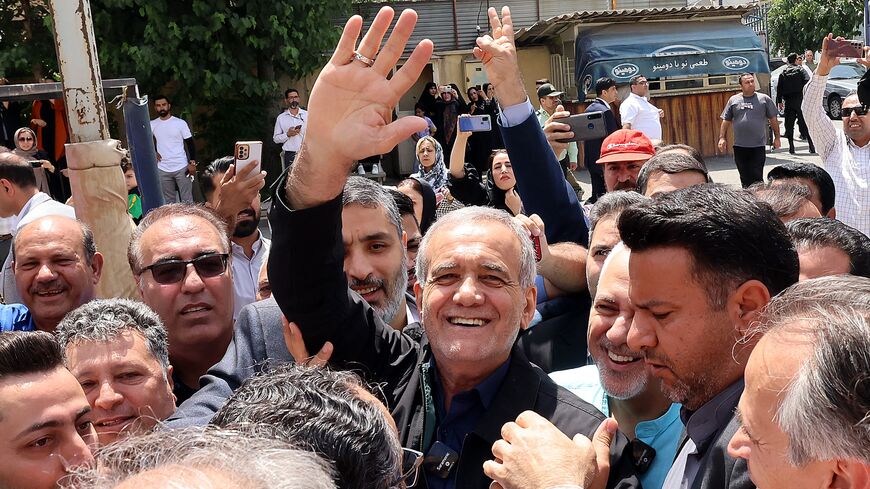 Iranian reformist presidential candidate Masoud Pezeshkian (C) gestures while surrounded by supporters outside a polling station in Tehran on July 5, 2024. 
