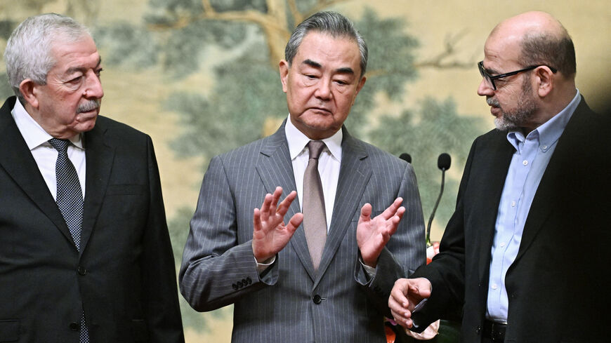 (L-R) Mahmoud al-Aloul, Vice Chairman of the Central Committee of Palestinian organisation and political party Fatah, China's Foreign Minister Wang Yi, and Mussa Abu Marzuk, senior member of the Palestinian Islamist movement Hamas, attend an event at the Diaoyutai State Guesthouse in Beijing on July 23, 2024. China's Foreign Minister Wang Yi on July 23 hailed an agreement by 14 Palestinian factions to set up an "interim national reconciliation government" to govern Gaza after the war. (Photo by Pedro Pardo 