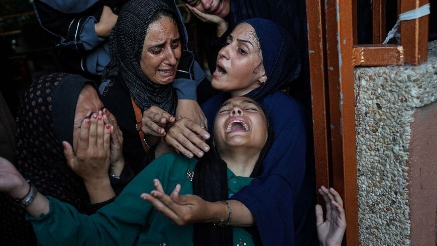 Palestinian women cry as killed members of the Abu Taha family are brought for burial, outside Nasser hospital in Khan Yunis following Israeli bombardment east of the city in the southern Gaza Strip