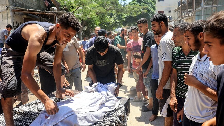 A body is wrapped in a white sheet after Israeli bombardment at the al-Bureij refugee camp in the central Gaza Strip on July 9, 2024