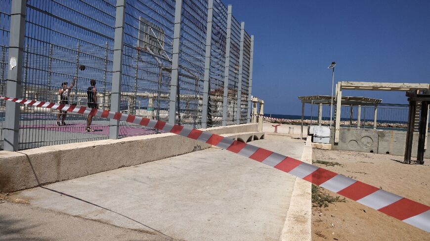 A strip of red and white tape blocks the beach entrance in the Israeli port city of Haifa during a major exchange of fire between Israeli forces and Lebanon's Hezbollah