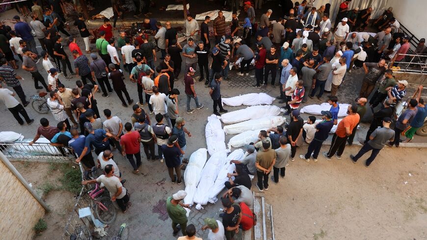 Shrouded bodies lie at a hospital after an Israeli strike that Gaza's civil defence agency said killed 93 people including women and children at a school sheltering war displaced