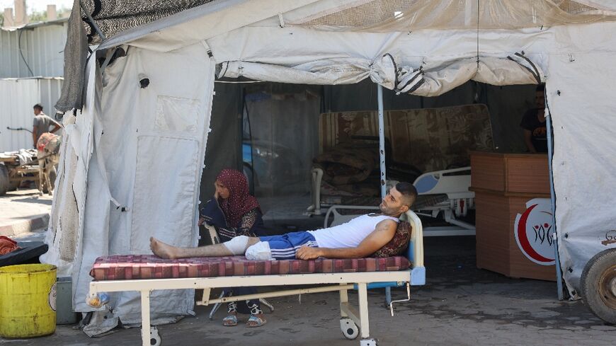 An injured Palestinian man awaits evacuation from the Al-Aqsa Martyrs hospital in Deir el-Balah following renewed Israeli evacuation orders for the area