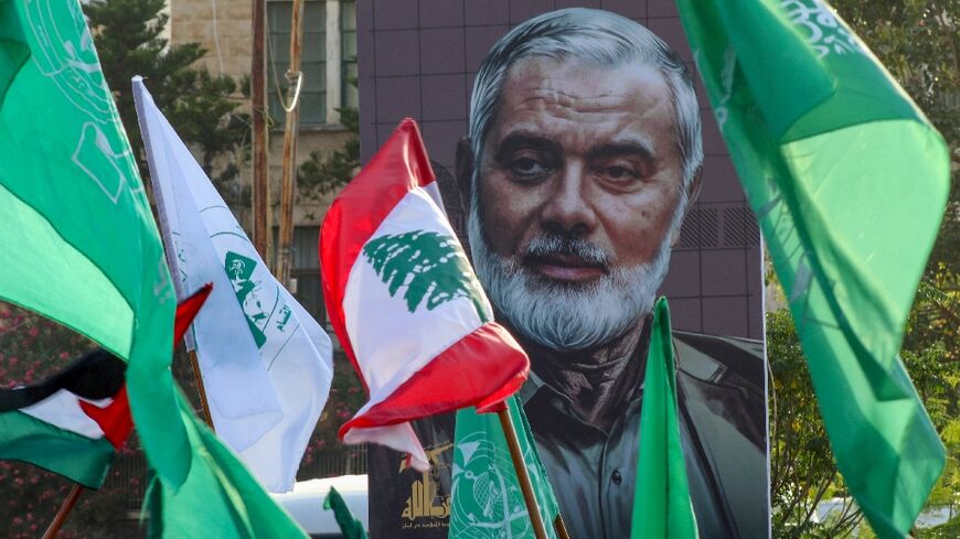 A portrait of slain Hamas political leader Ismail Haniyeh provides a backdrop to a demonstration, in Lebanon's Sidon city, denouncing his killing and that of a senior Hezbollah's commander