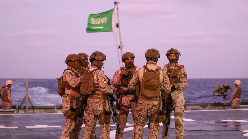 Saudi security officers stand guard onboard a Saudi vessel docked off the seaport of Port Sudan on April 30, 2023, during evacuations efforts from Sudan. - Heavy fighting again rocked Sudan's capital as tens of thousands have fled the bloody turmoil and a former prime minister warned of the "nightmare" risk of a descent into full-scale civil war. Foreign nations have scrambled to evacuate thousands of their citizens by air, road and sea since the fighting plunged the poverty-stricken country into deadly tur