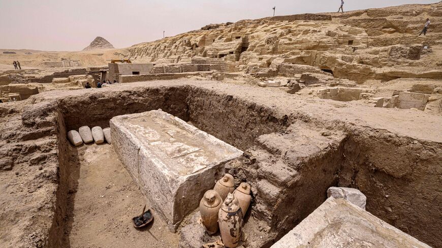 Visitors tour the site in the Saqqara necropolis south of Cairo, where archaeologists unearthed two human and animal embalming workshops, as well as two tombs, on May 27, 2023. The head of Egypt's Supreme Council of Antiquities, told reporters the embalming workshops, where humans and animals were mummified, "date back to the 30th dynasty" which reigned around 2,400 years ago. (Photo by Khaled DESOUKI / AFP) (Photo by KHALED DESOUKI/AFP via Getty Images)