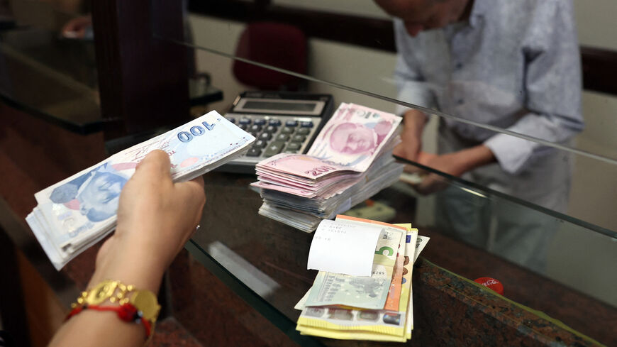 A customer buys US dollars in exchange for Turkish lira at an exchange office in Ankara, Turkey, July 20, 2023.