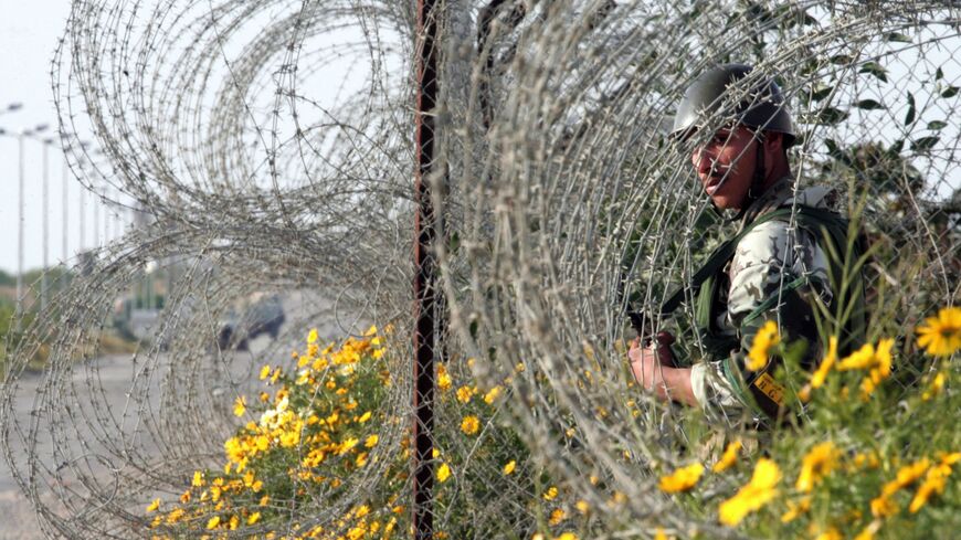 An Egyptian army soldier stands among the bushes in the wired border of the Philadelphi Corridor.