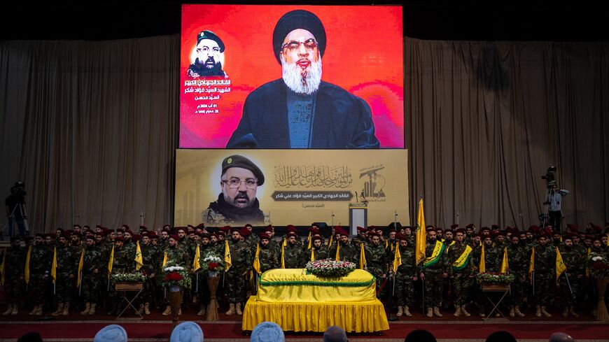 The coffin of Hezbollah commander Fouad Shukr is flanked by Hezbollah reservists.