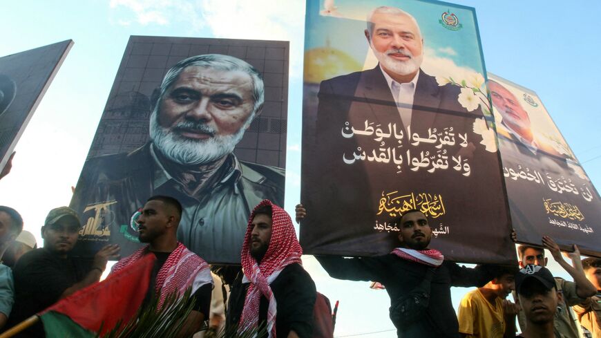 People take part in a march called by Palestinian and Lebanese youth organizations in the southern Lebanese city of Saida on August 5, 2024, to protest against the assassination of Hamas chief Ismail Haniyeh (portrait) and a Hezbollah military commander. 