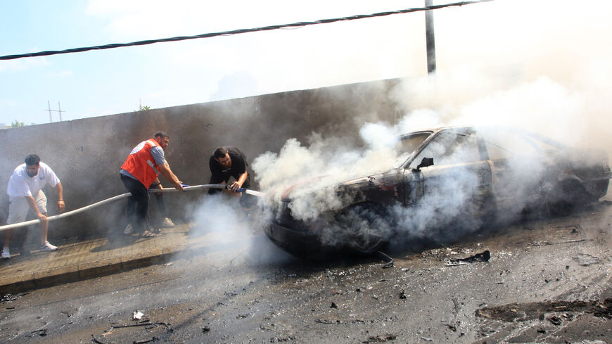 Lebanese firefighters put out a fire in a car after an Israeli strike in the southern city of Sidon on August 21, 2024. An Israeli strike in Lebanon's southern city of Sidon on August 21, killed a Fatah official, said a leader from the Palestinian group and a security source, marking the first such attack reported on Fatah in over 10 months of cross-border clashes. (Photo by Mahmoud ZAYYAT / AFP) (Photo by MAHMOUD ZAYYAT/AFP via Getty Images)