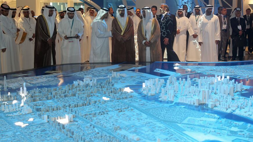 Sheikh Hamed bin Zayed Al Nahyan (C), who was recently named to head the Abu Dhabi Investment Authority, looks at a model of the Capital City District project.